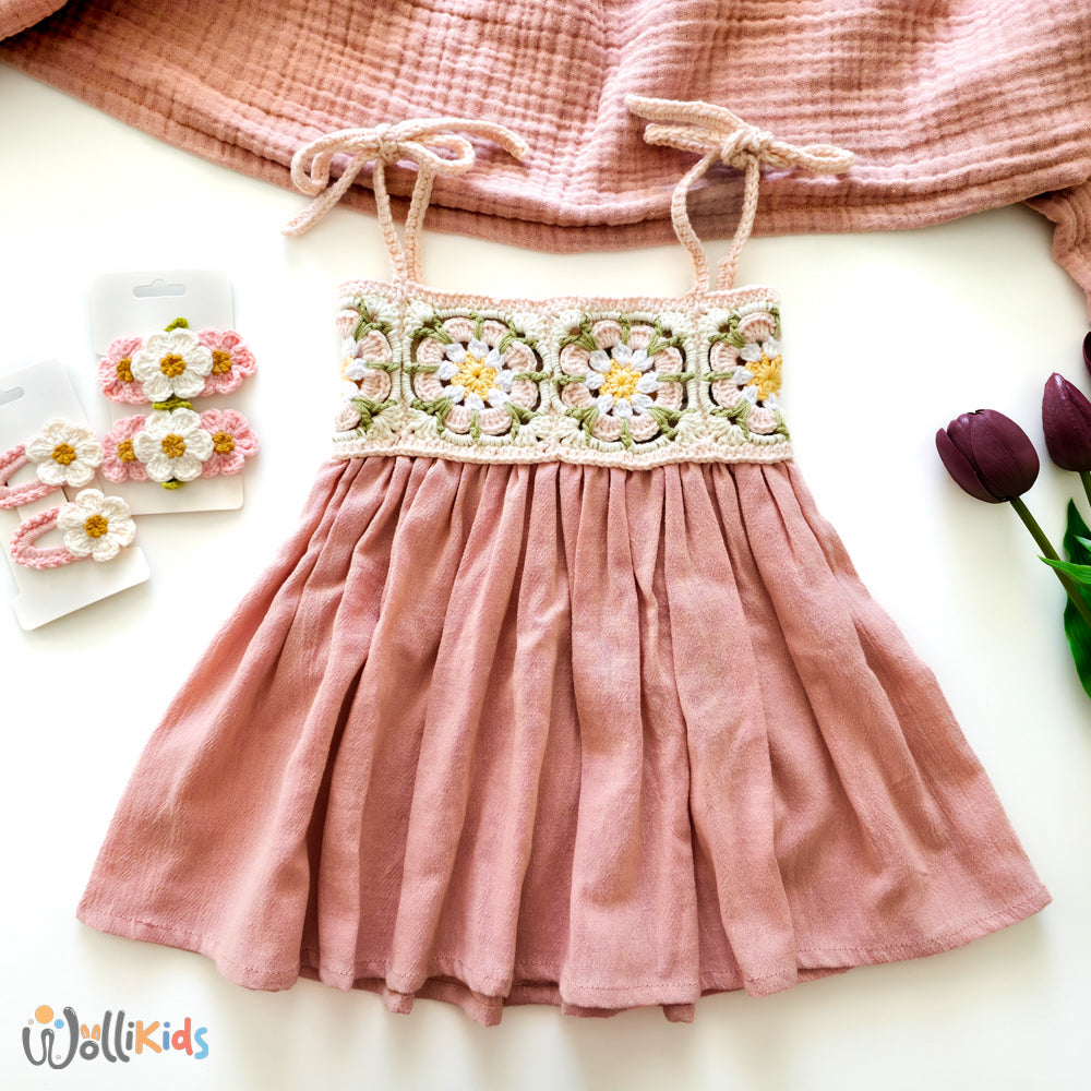 Rosa Sommerkleid für Babys mit gehäkeltem Oberteil und floralen Details, kombiniert mit handgefertigten Häkelblumen-Haarspangen.